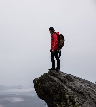 Financially Independent Retirement Depicted as Man on Mountain Summit
